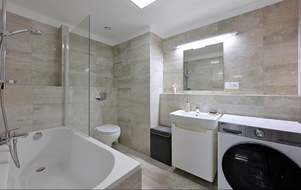 Velká Koupelna S Vanou Je Zařízena Minimalisticky, Jediný Kus Nábytku Je Malá Skříňka Pod Umyvadlem V Povrchové úpravě Lesklý Lak